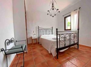 une chambre avec un lit et un lustre dans l'établissement Agradable casa de playa con piscina. El Palmar, à El Palmar 30 autres photos