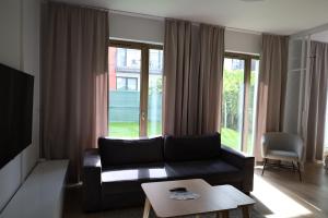 sala de estar con sofá y ventana grande en Blue16 by OneApartments, en Gdansk