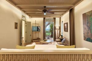 a living room with a bed and a ceiling fan at Charras Bhawan Hotel and Residences in Hua Hin