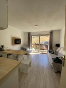 een keuken en een woonkamer met uitzicht op een balkon bij Home Sweet Sauze - Chaleureux appartement - Lumineux et calme - Vue sur la montagne in Enchastrayes