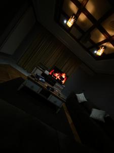 Habitación oscura con cama, mesa y luces. en Centre ville hay Riad 06 69 soixante-huit trente-huit vingt-huit en Ifrane