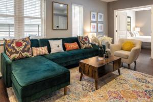 a living room with a green couch and a coffee table at Stunning 2BR Apartment Near Downtown in Cincinnati