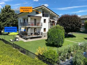 Una casa con un cartel que dice "agente de acreditación de apartamentos" en Il Tiglio Gressan, en Aosta