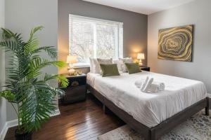 a bedroom with a large bed and a plant at Stunning 2BR Apartment Near Downtown in Cincinnati