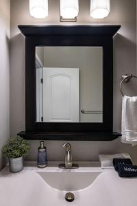 La salle de bains est pourvue d'un miroir et d'un lavabo. dans l'établissement Stunning 2BR Apartment Near Downtown, à Cincinnati