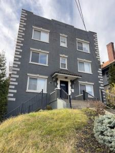 une maison grise avec des fenêtres blanches sur une colline dans l'établissement Stunning 2BR Apartment Near Downtown, à Cincinnati