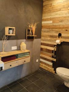 baño con pared de madera y aseo en La guitoune en Laroque