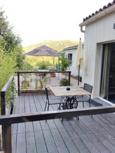 una terraza de madera con mesa y sillas. en La guitoune en Laroque