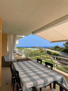 einen Tisch und Stühle auf einem Balkon mit Meerblick in der Unterkunft Beautiful apartment with sea view and great pool in Portocolom