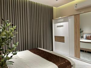 a bedroom with a bed and a curtain at شقة فاخرة غرفة وصالة بالعارض دخول ذاتي ١٠ in Riyadh