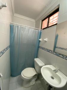 a bathroom with a toilet and a sink at Hotel Napoles Valledupar in Valledupar