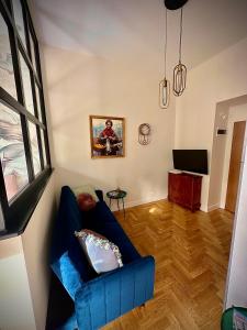 een woonkamer met een blauwe bank en een televisie bij HOUSEHOST Apartment: Łazarza street in Krakau