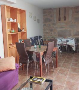 sala de estar con mesa de madera y sillas en Casa das Peleteiro Ribeira Sacra en Ourense