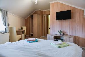 a bedroom with a bed with a tv on the wall at Migro Lux sobe in Arilje