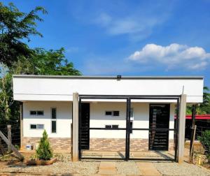 un edificio blanco con puertas negras en un patio en Casa Campestre Villa Maria, en San José del Guaviare