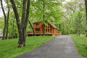 a log cabin in the woods with a driveway at Home Sweet Log in Wisconsin Dells