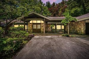 a stone house with a driveway in front of it at Bourbon Hollow Lodge with Hot Tub and Pool plus Game Room only 5 min to downtown in Gatlinburg