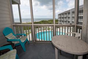 a balcony with a table and chairs and a view of the ocean at Dunescape Villas 221 in Atlantic Beach