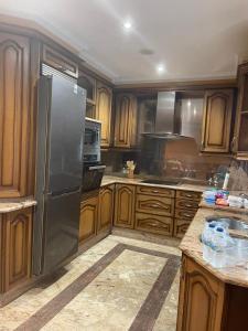 a kitchen with wooden cabinets and a stainless steel refrigerator at PRIMERA LINEA PLAYA AMERICA in Nigrán