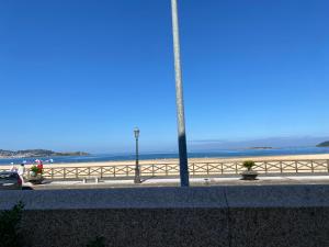 een uitzicht op het strand en de oceaan vanaf een muur bij PRIMERA LINEA PLAYA AMERICA in Nigrán