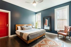 1 dormitorio con paredes azules, 1 cama y puerta roja en Lux Washington Park with Rooftop Patio, en Cincinnati