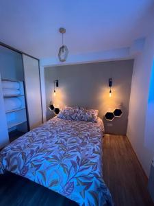 a bedroom with a bed with a blue comforter at T2 cabine 6 pers au pied des pistes in Orcières