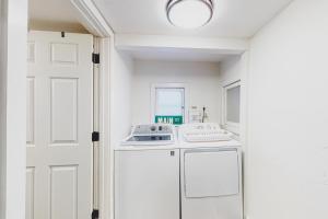 a white kitchen with a sink and a refrigerator at The Pink House on Main in Eureka Springs +12 photos