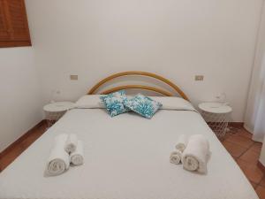 una camera da letto con un letto con asciugamani e due tavoli di Casa Gio' IUN R4246 a Solanas