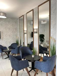 a waiting room with blue chairs and tables and mirrors at ĆAKA Luxury Rooms & Restaurant in Ćuprija