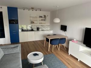 a kitchen and living room with a table and chairs at Baltic Nest - Dziwnów in Dziwnów