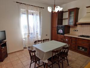 una cucina con tavolo, sedie, tavolo e televisore di Mari e Monti a Scano Montiferro