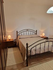 una camera con un letto e due lampade sui tavoli di Mari e Monti a Scano Montiferro