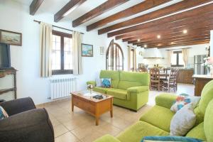 uma sala de estar com cadeiras verdes e uma mesa em Villa SOlivellas by Villa Plus em El Port