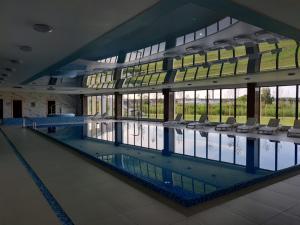 a large swimming pool with chairs in a building at Baltic Nest - Dziwnów in Dziwnów