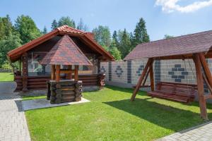 a playground with a building and a gazebo at Pensiunea Sofy Mar in Poiana Micului