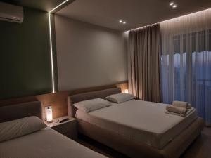 een hotelkamer met 2 bedden en een raam bij Hotel Ble Ble Vlore in Vlorë