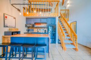 uma cozinha com armários azuis e um balcão com bancos em Lift West #215 em Red River