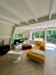 - un grand salon avec un canapé et une table dans l'établissement Vakantiewoning Sunclass Durbuy Ardennen huisnummer 68, à Durbuy