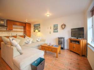 a living room with a couch and a flat screen tv at Charismatic Cottage near St Ives (Atlantic) in Saint Erth