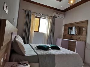 a bedroom with a bed with two pillows on it at Studio de luxe chez FOUR IN ONE Résidence in Limbe +47 photos