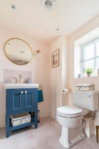 a bathroom with a blue cabinet and a toilet at Cotswolds Cottage 5min from Soho Farmhouse in Chipping Norton