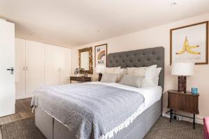 ein Schlafzimmer mit einem großen Bett mit einer blauen Decke in der Unterkunft Cotswolds Cottage 5min from Soho Farmhouse in Chipping Norton