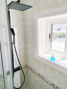 um chuveiro na casa de banho com uma janela em Amplio piso de confort. em Vigo