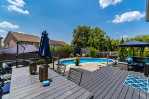 a deck with a pool and a table with umbrellas at Poolside Perfection, Culinary Delight in Mississauga