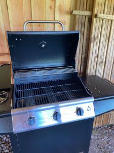 a black barbecue grill sitting next to a wooden wall at Kroghs Tiny Houses - Hyttebyen in Grindsted