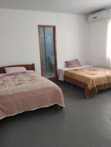 1 dormitorio con 2 camas y ducha. en POUSADA DA PONTE IBIRAQUERA, en Imbituba