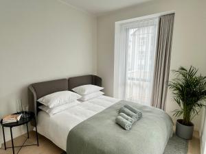 a bedroom with a large bed with a large window at Brand new city centre apartment, free parking spot in Tallinn