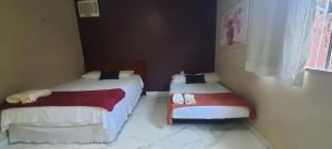 two twin beds in a room with at Hospedaria Salém in Soure