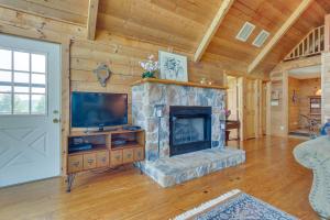 ein Wohnzimmer mit einem Steinkamin und einem TV in der Unterkunft Stunning Gore Vacation Rental on 10 Acres of Land! 
