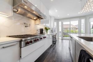 a kitchen with white counters and a stove top oven at Poolside Perfection, Culinary Delight in Mississauga